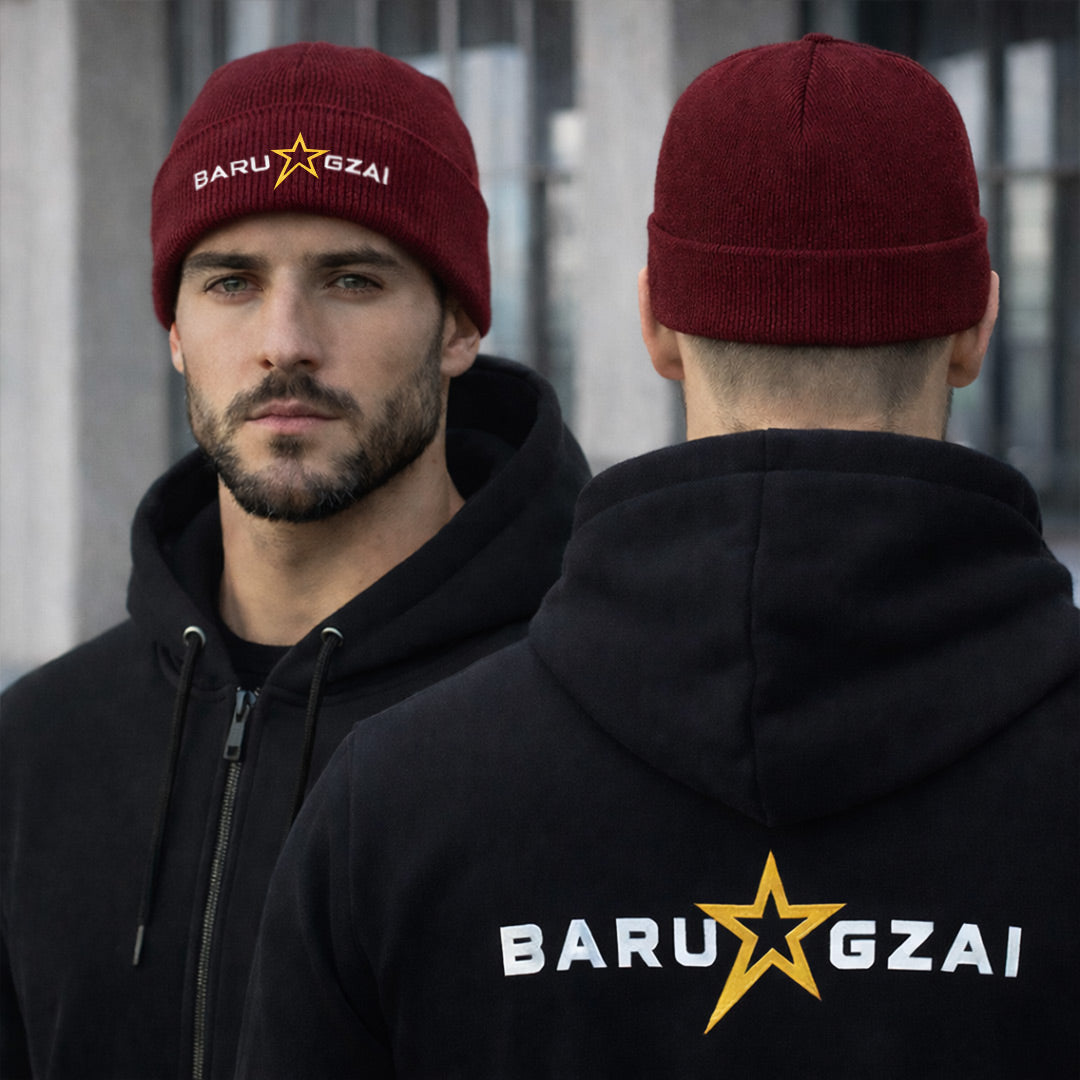 Male wearing burgundy barugzai beanie folded in an urban setting with a barugzai hoodie.