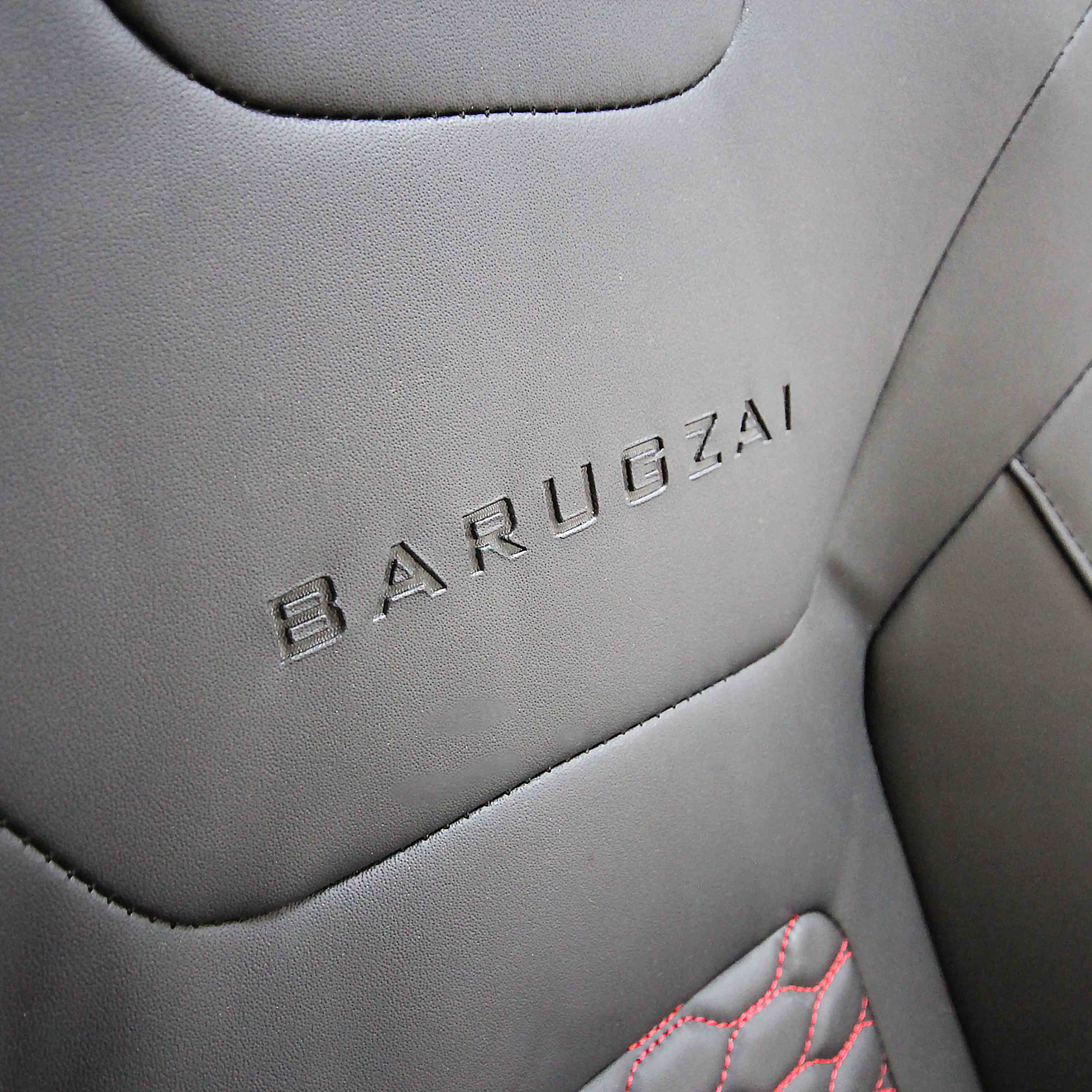 Close-up of a black leather surface with 'BARUGZA' branding.