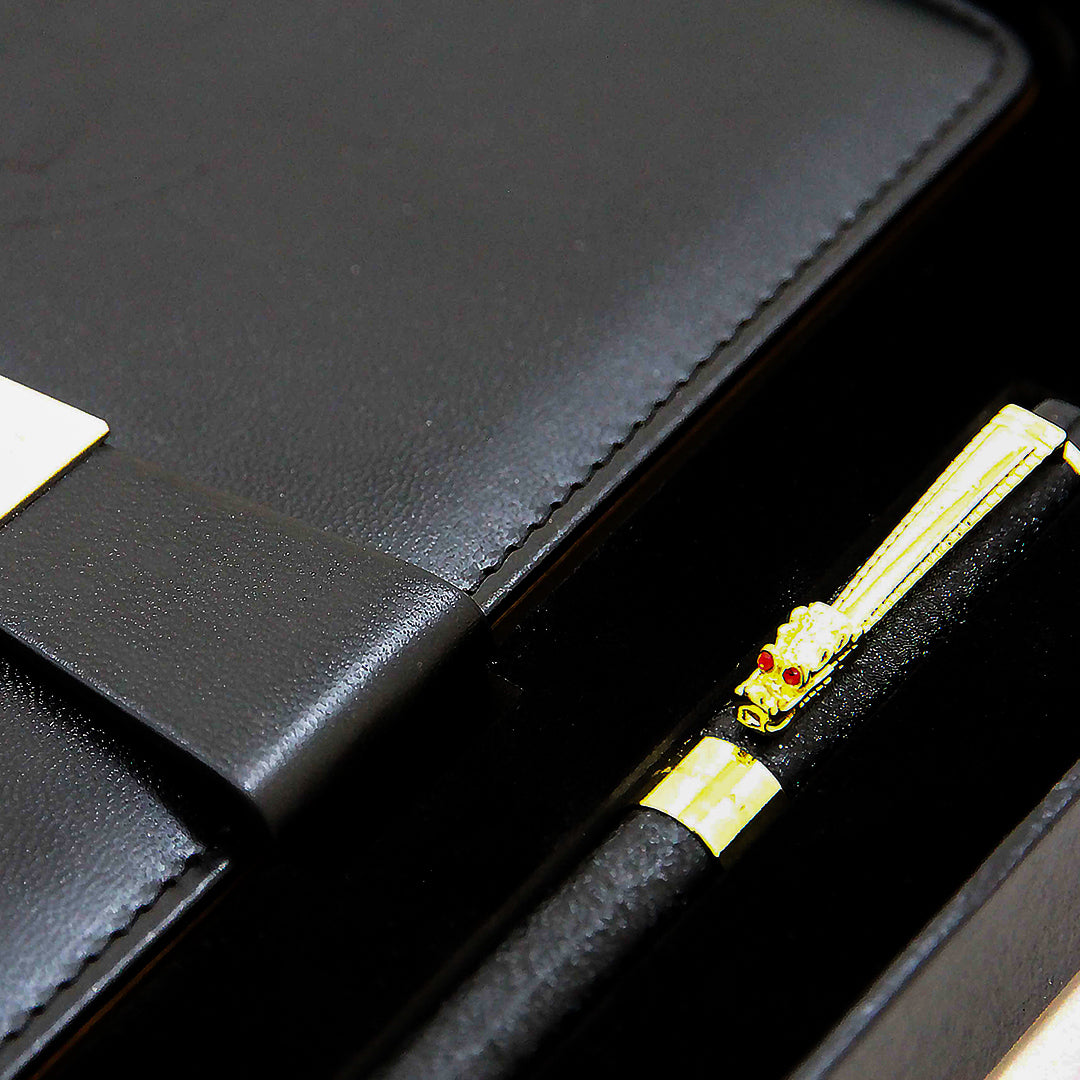 Black pen with gold accents in a black leather case.