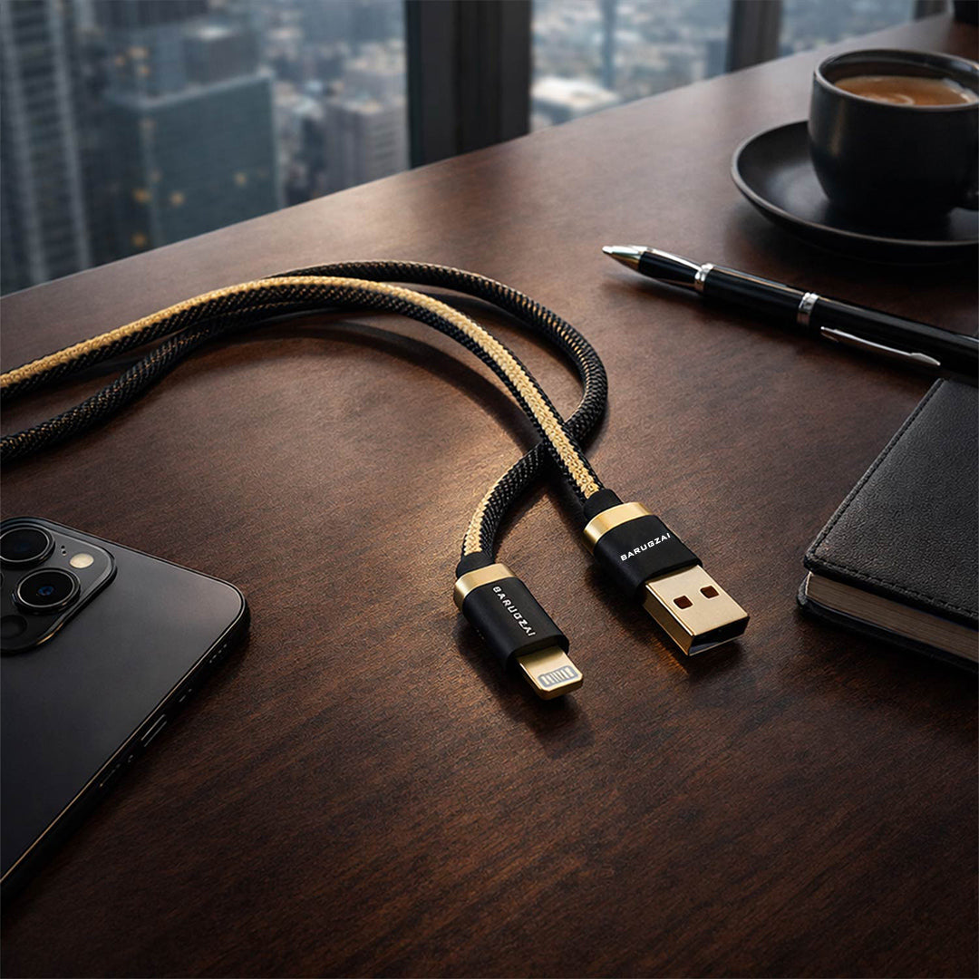 Phone cable on a wooden desk with a phone, pen, and coffee cup in the background.