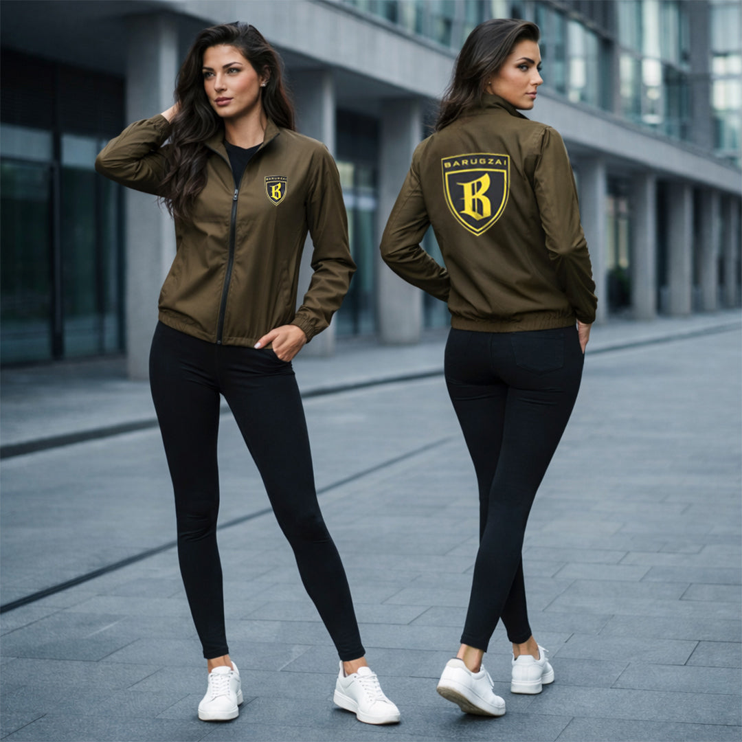 Woman wearing a green olive brown jacket with a barugzai shield logo, standing on a city street.