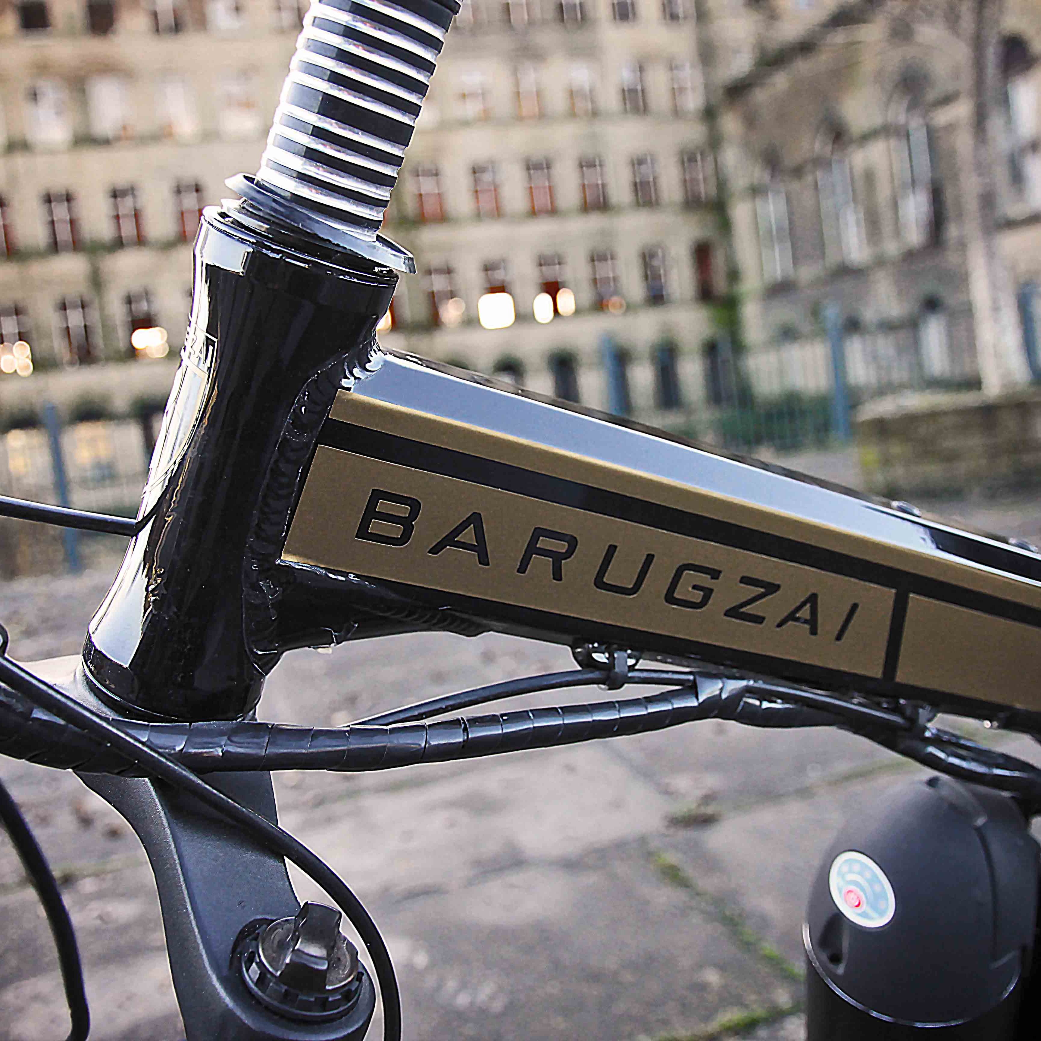 Close-up of a bicycle frame with 'BARUGZAI' branding in an urban setting.