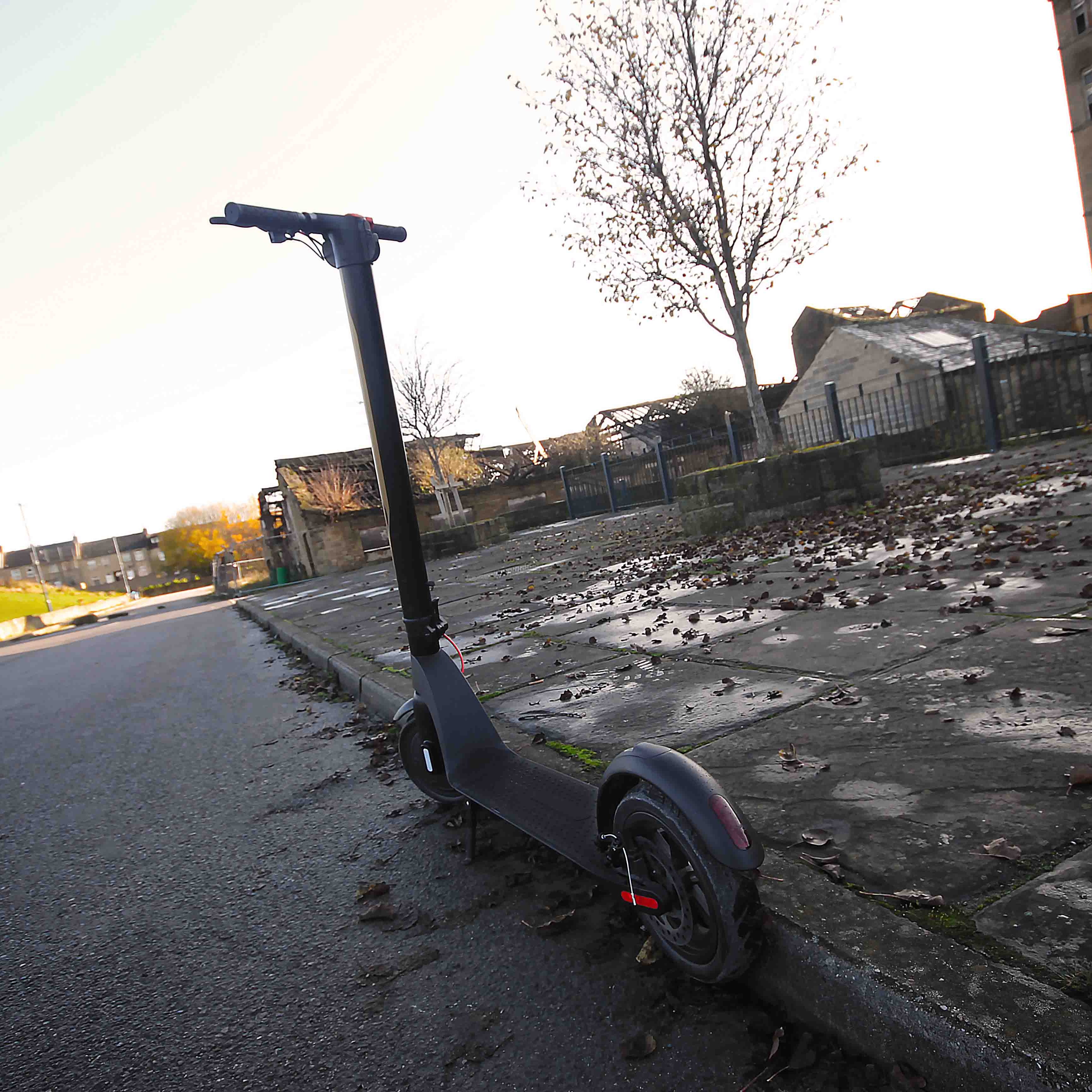 Electric scooter on a street with buildings and trees in the background