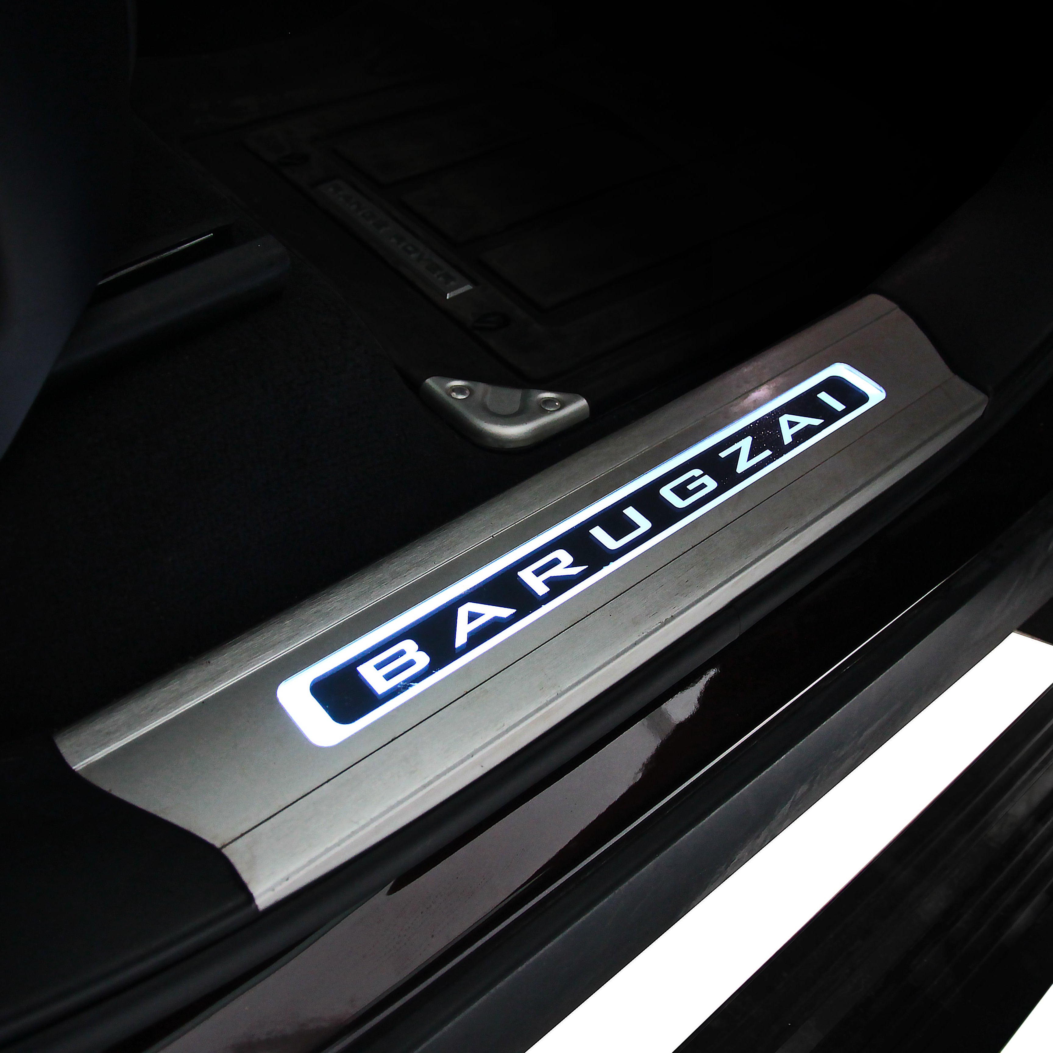 Car door sill plate with 'BARUGZAI' branding on a dark interior background.