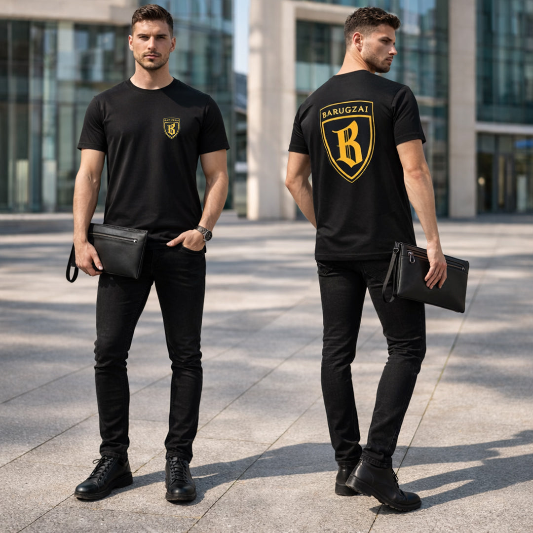 Man wearing a black barugzai shield t-shirt with a logo, standing in an urban setting, holding the leather barugzai black clutch bag. 
