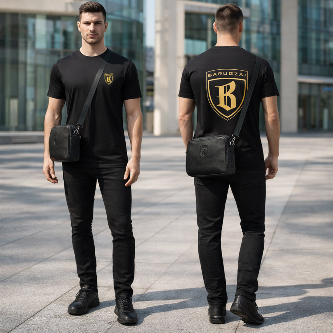Man wearing a black Barugzai Logo t-shirt with a logo and carrying a black man bag in an urban setting.