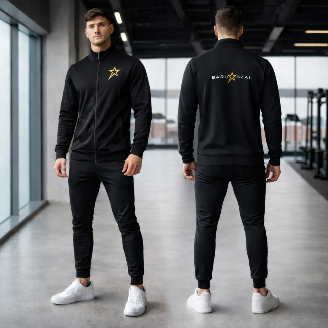 Male wearing a black tracksuit with a logo in an indoor gym setting.