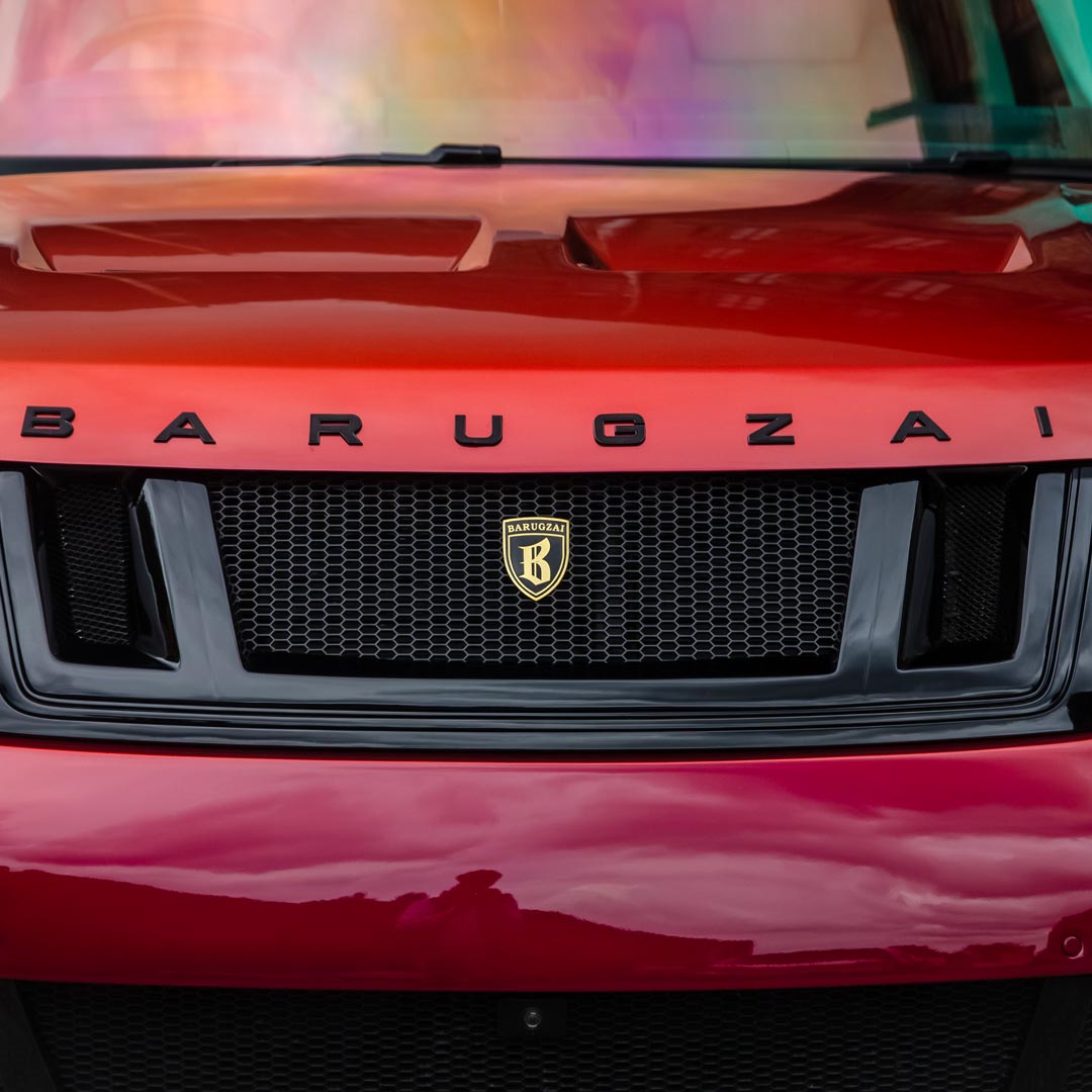 Close-up of the Red Range Rover front grille with Barugzai lettering and branding details.